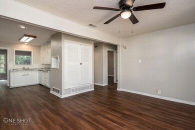 Unfurnished living room with ceiling fan, dark har