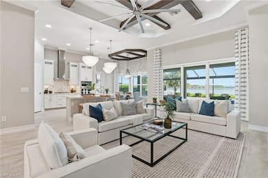 Living room featuring coffered ceiling, beam ceiling, light wood-type flooring, a towering ceiling, and recessed lighting