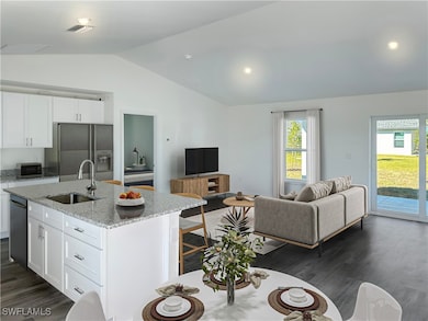 Kitchen with a sink, lofted ceiling, refrigerator