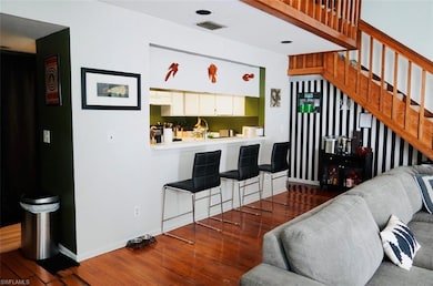 Living area featuring baseboards, stairs, hardwood