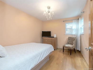 Bedroom featuring light wood-style floors and a chandelier