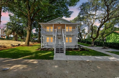 View of front facade with stairway, a porch, and a lawn