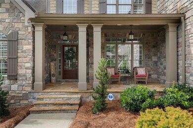 Property entrance featuring covered porch and ston