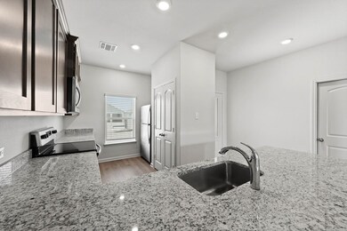 Kitchen with light stone countertops, stainless steel appliances, light wood-style flooring, and recessed lighting