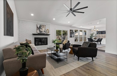 Living room with lofted ceiling, a fireplace, light wood-type flooring, recessed lighting, and ceiling fan