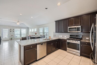 Kitchen with lofted ceiling, appliances with stai