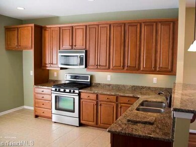 Kitchen. Great Kitchen!  Cherry stained cabinetry, stainless appliances, granite countertops, recessed and pendant lighting and eating bar!  Sliding door to grilling porch overlooking pond.