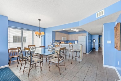 Tiled dining space with a textured ceiling and a c