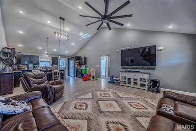 Living area featuring high vaulted ceiling, light wood-style flooring, ceiling fan, and recessed lighting