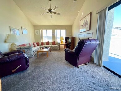 Carpeted living area featuring vaulted ceiling, a