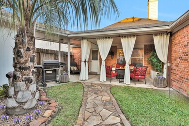 The backyard oasis features a Covered Patio, stone