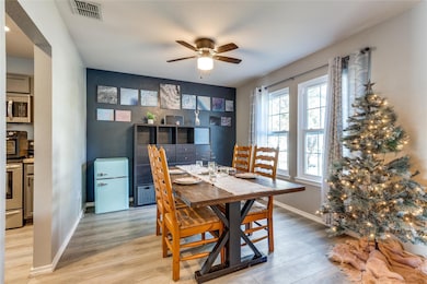 Dining area with ceiling fan and light hardwood / 