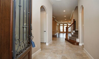 Impressive Two-Story Entry Way with Wrought Iron Front Door.