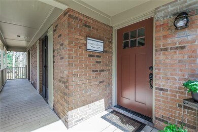 View of the spacious covered front porch and beautiful custom entry door.