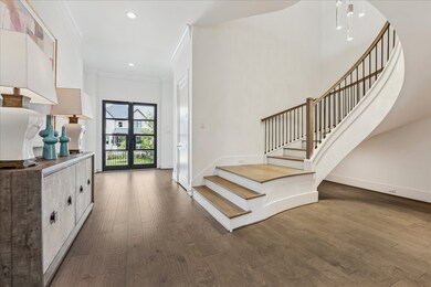 This bright entryway features wide-plank wood floo