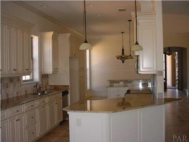 Kitchen has tile floors, stone backsplash, custom cabinets including a pantry with pull out shelves, and granite countertops.