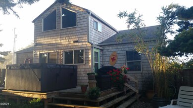 Back of home with hot tub