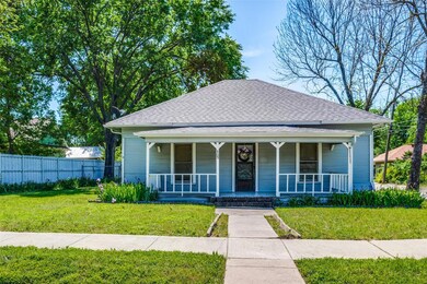 Bungalow-style house with a front lawn and covered