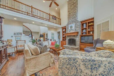 The family room has a floor to ceiling stone fireplace as its focal point.  With volume ceilings and a bank of windows to the outdoor living area this bright, airy space sits just off the kitchen.