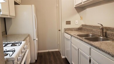 Kitchen with white appliances, a sink, dark wood-