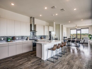 Kitchen featuring a center island with sink, white