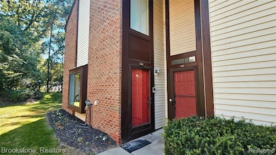 Entrance to property featuring brick siding and a lawn