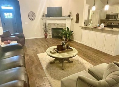 Living room with dark hardwood / wood-style floors and a tiled fireplace