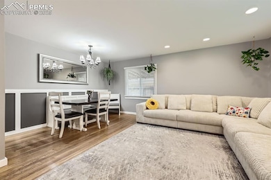 Living room featuring natural wood floors and a chandelier.
