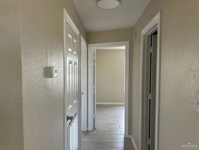 Hall featuring a textured wall and wood tiled floors