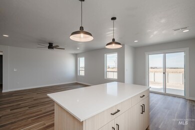 Kitchen featuring light brown cabinetry, recessed lighting, a center island, open floor plan, and decorative light fixtures