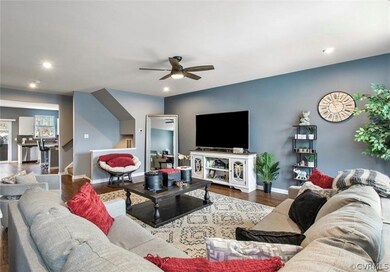 Living room featuring dark wood-type flooring and ceiling fan