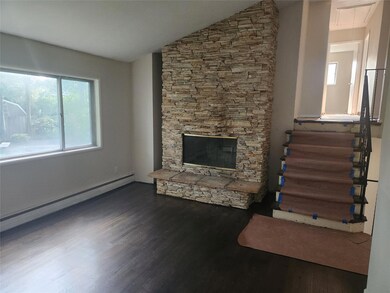 Living Room with vaulted ceiling and fireplace with stone surround