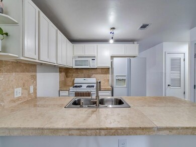 Kitchen with tasteful backsplash, white appliance