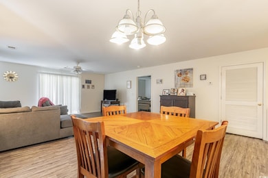 Dining room featuring light hardwood / wood-style flooring and ceiling fan with notable chandelier