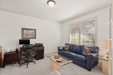 Bright home office framed by glistening French doors and classic plantation shutters — a serene, stylish space perfect for focus, creativity, or quiet morning emails.