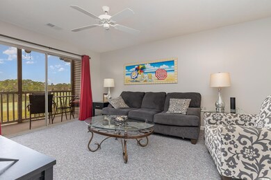 Carpeted living room with ceiling fan