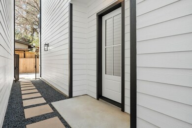 Modern side entrance with clean white siding, blac