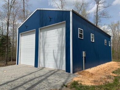 1,500 sq ft storage building with water, power, RV hook-up, septic, and a cleared spot for a home.