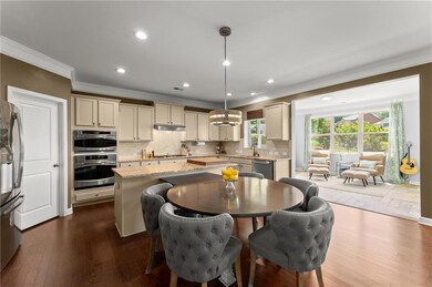 Kitchen with crown molding, stainless steel appliances, a kitchen island, backsplash, and dark wood-type flooring