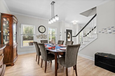 Dining space with crown molding and light hardwood