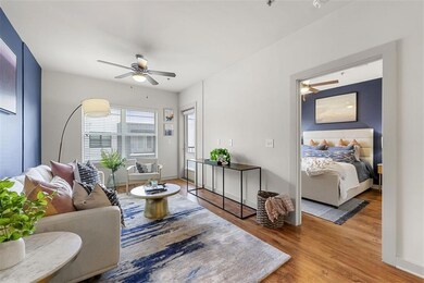 Living room with ceiling fan and wood-type floorin