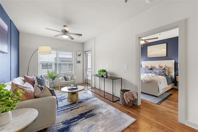 Living room with ceiling fan and wood-type flooring
