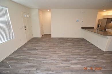 Unfurnished living room featuring wood finished fl