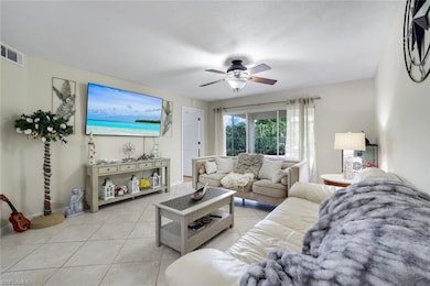 Living area featuring light tile patterned floors and a ceiling fan