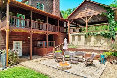 Back of property featuring a patio, an outdoor living space with a fire pit, and stairway