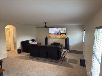 Living area featuring arched walkways, carpet flo