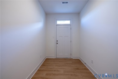 Entryway with wood finished floors and baseboards