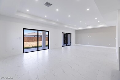Empty room with a tray ceiling, recessed lighting,