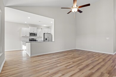 Unfurnished living room featuring ceiling fan, lig