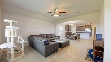 Living area with arched walkways, light tile patte